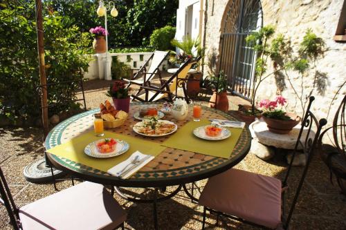 - une table avec des assiettes de nourriture sur une terrasse dans l'établissement Chambres d'hôtes Les Terrasses du Soleil, à Cagnes-sur-Mer