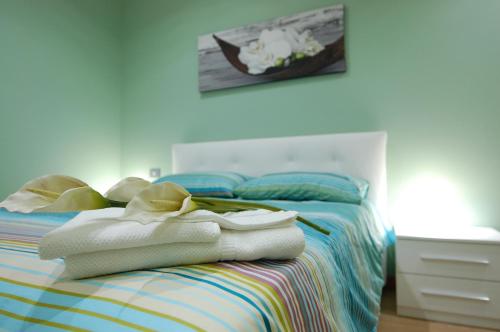 Vacanze Romane Olgiata في لا سْتورتا: غرفة نوم عليها سرير وفوط
