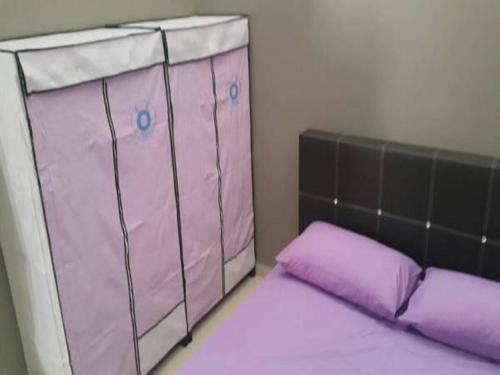 ein rosafarbenes Kinderbett mit lila Kissen in einem Zimmer in der Unterkunft Taman Tanjung Minyak in Malakka
