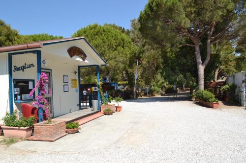 a woman standing in front of a store with a sign at Giannella Camping in Orbetello