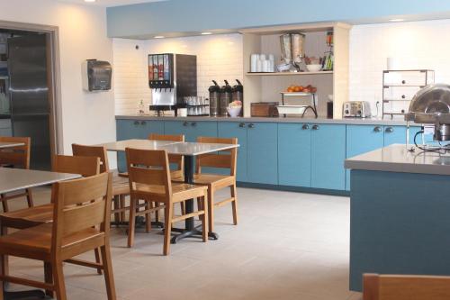 a kitchen with blue cabinets and wooden tables and chairs at Country Inn & Suites by Radisson, Nashville, TN in Nashville