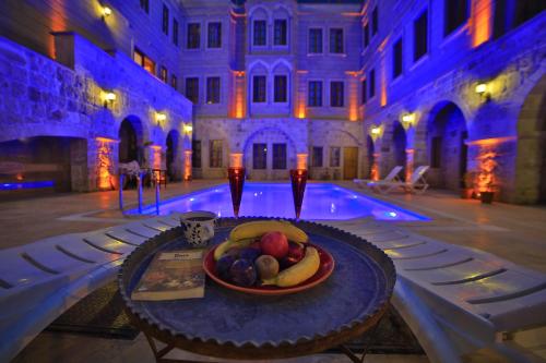 a plate of fruit on a table next to a pool at Grand Cappadocia Hotel in Göreme