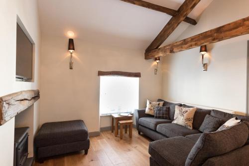 uma sala de estar com um sofá e uma cadeira em The Old Hay Loft em Kirkby Lonsdale