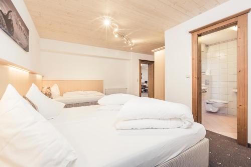 a bedroom with two beds and a bathroom at Leni Mountain Appartements in Sölden