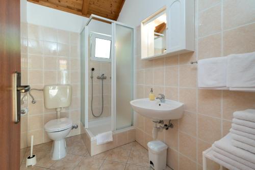 a bathroom with a toilet sink and a shower at Villas Oleandri in Vrboska