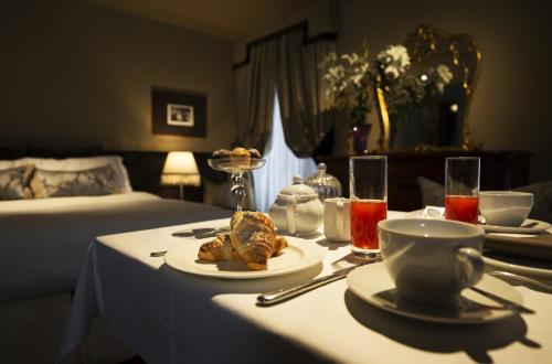 a table with a plate of food and drinks on it at Avogaria 5 Rooms in Venice