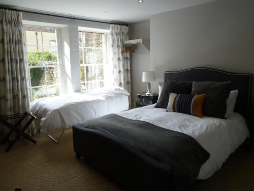 a bedroom with two beds and a window at Edgar Townhouse in Bath