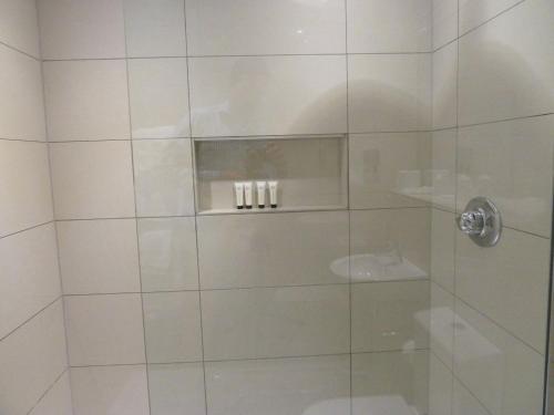 a shower with a glass door with three candles at Edgar Townhouse in Bath