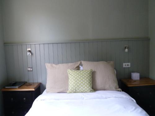 a bedroom with a bed with two nightstands and a pillow at Edgar Townhouse in Bath