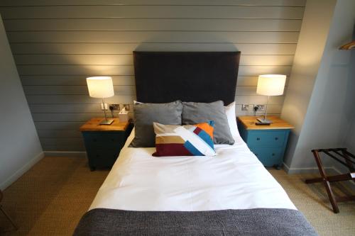 a bedroom with a bed with two night stands and two lamps at Edgar Townhouse in Bath