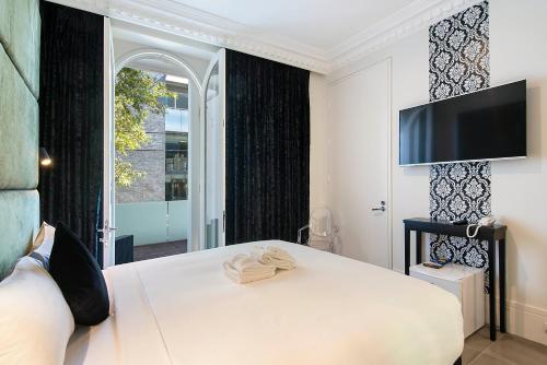a bedroom with a bed with a television on the wall at Sydney Boutique Hotel in Sydney