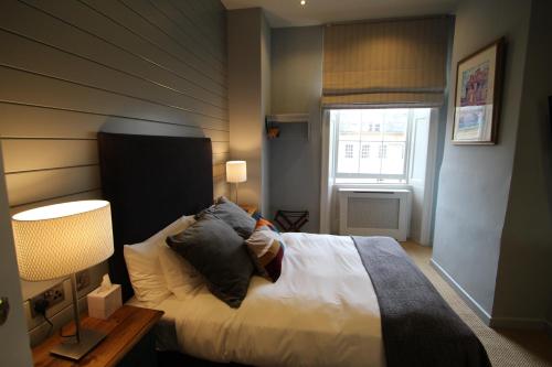 a bedroom with a bed and a window at Edgar Townhouse in Bath