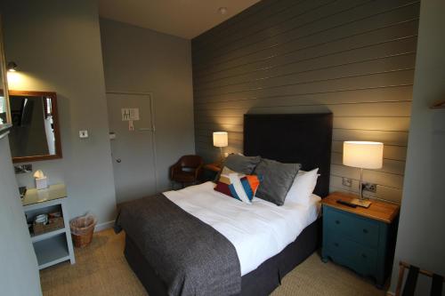 a bedroom with a large bed with a wooden wall at Edgar Townhouse in Bath