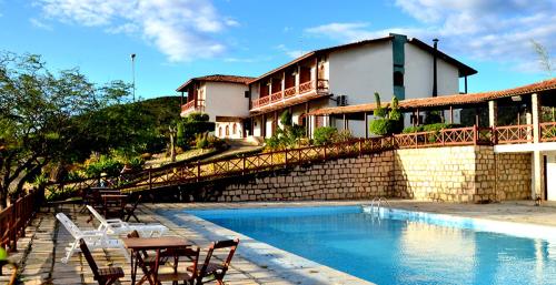 a resort with a swimming pool and a building at Hotel Serra do Ouro in Jacobina