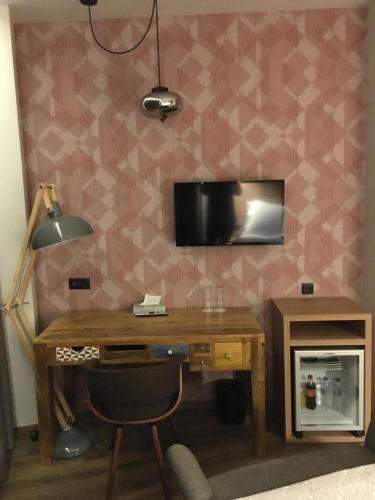 a desk with a lamp and a television on a wall at 360Degrees Pop Art Hotel in Athens