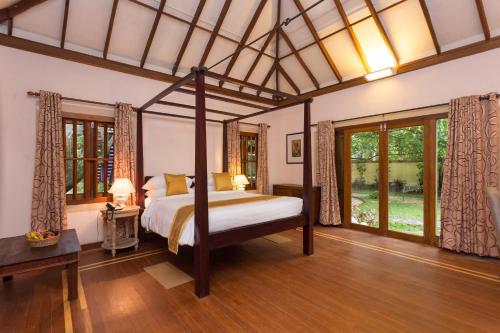 a bedroom with a canopy bed in a room at Azure Tides Marari in Mararikulam