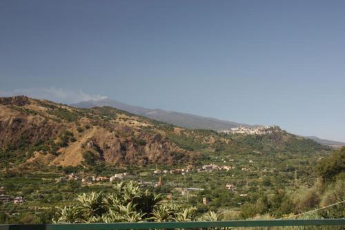 a view of a town on a mountain with palm trees at Agriturismo Ghiritina in Francavilla di Sicilia