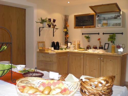 a kitchen with a counter and a table with bread at Naturpension Mühlhof in Neukirchen am Großvenediger