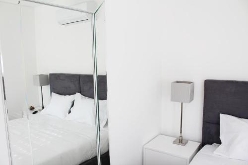 ein Schlafzimmer mit einem Spiegel neben einem Bett in der Unterkunft Bracara Guest House "Biblioteca" in Braga