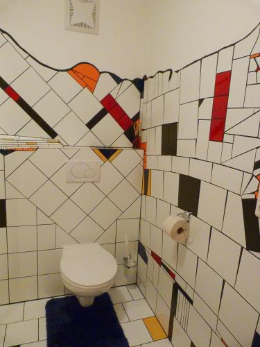 a bathroom with a toilet and tiles on the wall at Apart Annelies in Kauns