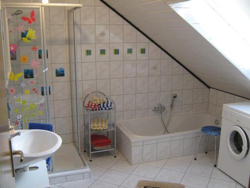 a bathroom with a shower and a tub and a sink at Ferienwohnung Sauerland Panorama in Korbach