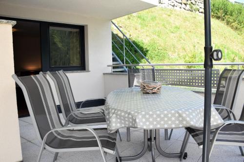 una mesa y sillas en un balcón con sombrilla en La Mezza Luna, en Kappl