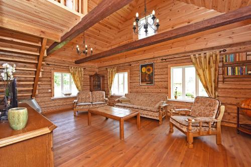 a living room with a couch and chairs in a cabin at Sodyba Puodžių Kaimas in Mackėnai