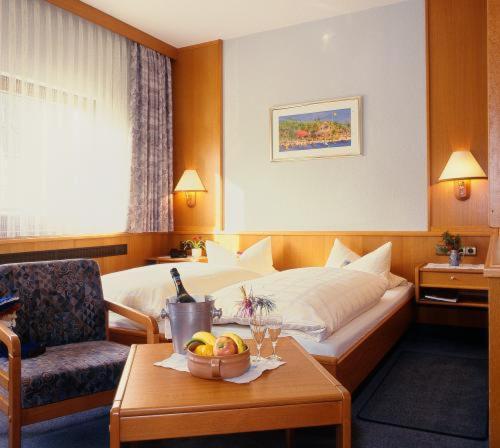 um quarto de hotel com uma cama e uma mesa com uma taça de fruta em Gasthof Schwarzer Bär em Kastl
