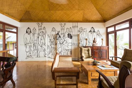 a living room with a mural on the wall at Azure Tides Marari in Mararikulam