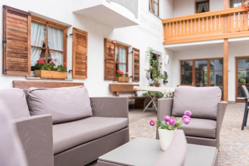 a patio with a couch and a table with flowers at Apartment Lodge Gasserhof in Bressanone