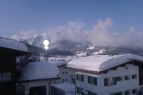 a view of a mountain with snow on the roofs of buildings at Appartement Seebacher in Hochfilzen