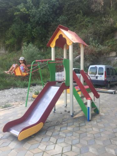 a playground with a slide and a person sitting at Apartments Kakadu in Sochi