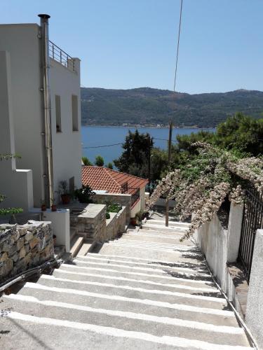 a path leading up to a building with a view of the water at Afroessa Studios & Apartments in Samos