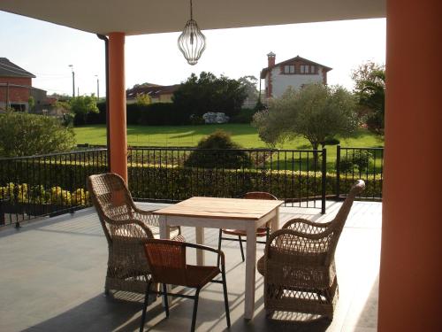 a table and chairs on a patio with a view of a yard at Posada la Desmera in Isla