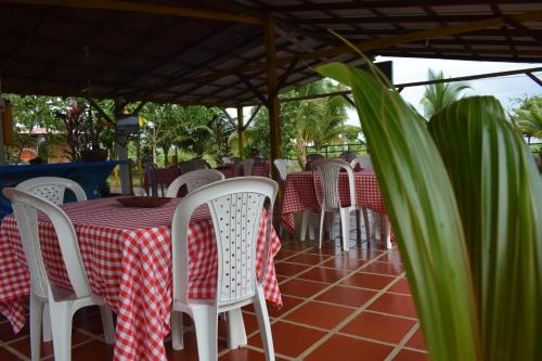 a table with white chairs and a red and white table cloth at Hotel Nuquimar in Nuquí