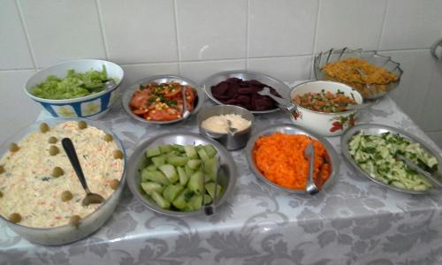 a table topped with bowls of different types of food at Hotel Santa Rita in Aparecida