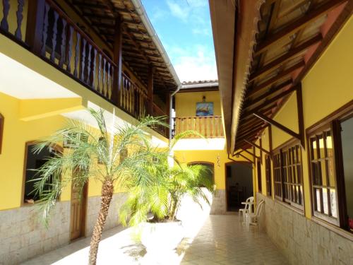 a building with two palm trees in a courtyard at Pousada Parque Imperial no centro de Paraty in Paraty