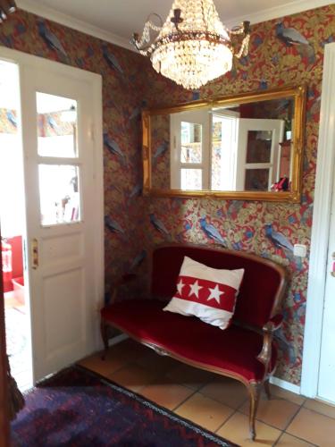 a room with a chair and a mirror and a chandelier at Älgbergets Bed & Breakfast in Ucklum