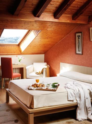a bedroom with a bed with a tray of food on it at El Milano Real in Hoyos del Espino