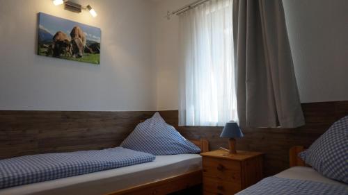 1 dormitorio con 2 camas individuales y ventana en Almblick Ferienwohnung, en Balderschwang