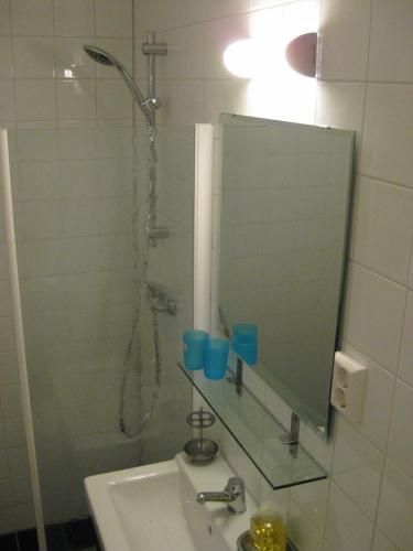 a bathroom with a shower with a mirror and a sink at Quarenta Studio in Amsterdam