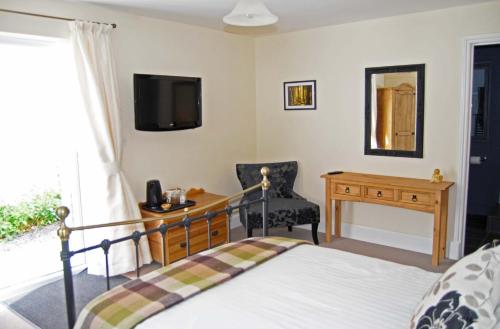 Dormitorio con cama, escritorio y TV en Highbury, en Abercych