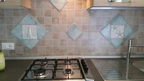 a kitchen counter with a stove and a sink at Sa Branda Costa Country Alghero in Santa Maria la Palma