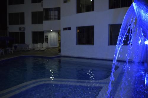 a blue water fountain in front of a building at Blue Star Hotel in Melgar