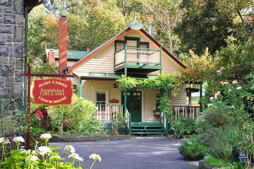 a small house with a porch and a balcony at Mary Cards Coach House in Olinda