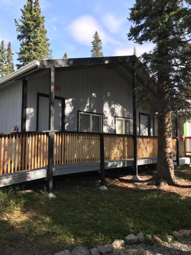 ein modulares Haus mit einem Zaun und einem Baum in der Unterkunft The Perch Resort in McKinley Park