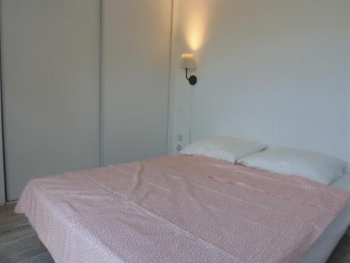 a bed with a pink blanket on top of it at Joli Mazet entre Montpellier et Nimes in Aimargues