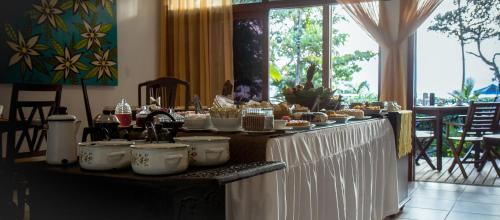a buffet of food on a table in a room at Porto dos Casais Guest House Itacaré in Itacaré