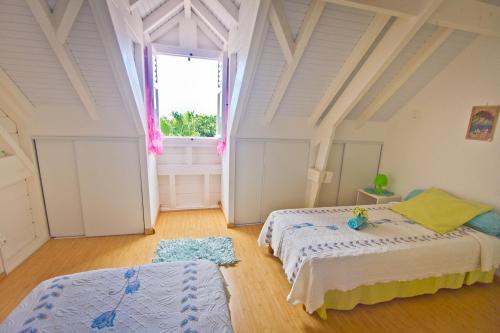 a bedroom with two beds and a large window at Résidence SIMONA in Deshaies