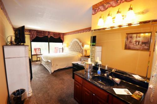 a bathroom with a bed and a sink and a mirror at Rivergate Mountain Lodge in Pigeon Forge